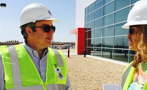 Two ECM employees in hard hats talking outside a building