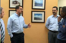 ECM colleagues talking in an office hallway